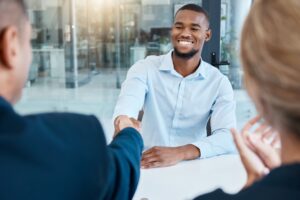 un alternant serrant la main d'un employeur lors d'un entretien d'embauche
